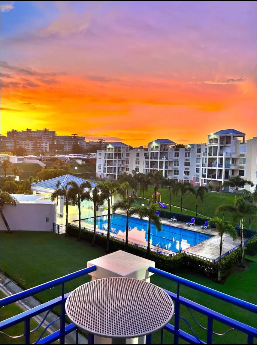 Atardecer anaranjado sobre la piscina del complejo de Costa Bella en Ceiba, visto desde el balcón